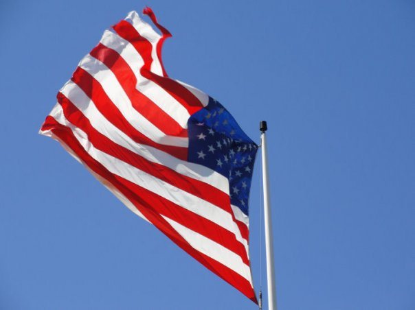 The American flag flying against a clear blue sky
