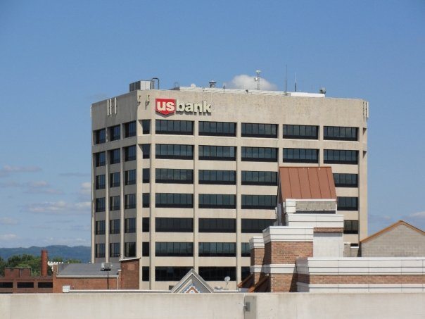 A downtown office tower rising against a clear blue sky